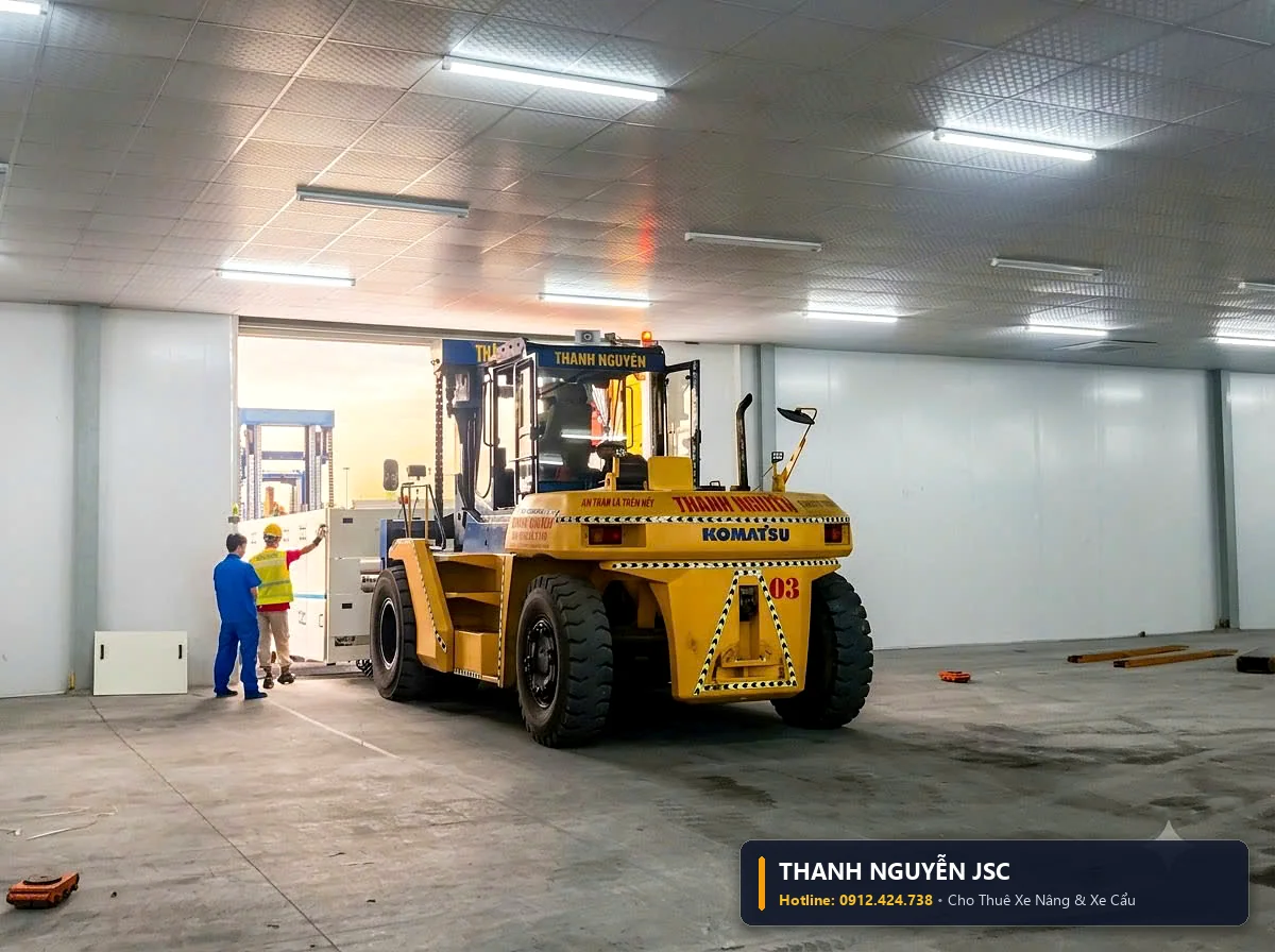 Xe nâng Komatsu điều khiển khéo léo đưa khối máy công nghiệp qua cửa hẹp vào xưởng sản xuất